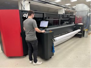 A member of the Venture Banners team with the EFI™ VUTEk® FabriVU® 340i Venture Banners marks 15th anniversary
